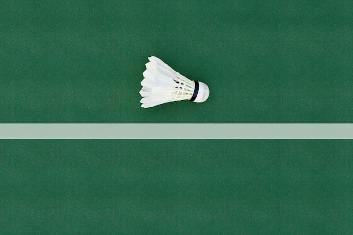 inzoomad badmintonboll nära en linje på en grön bana